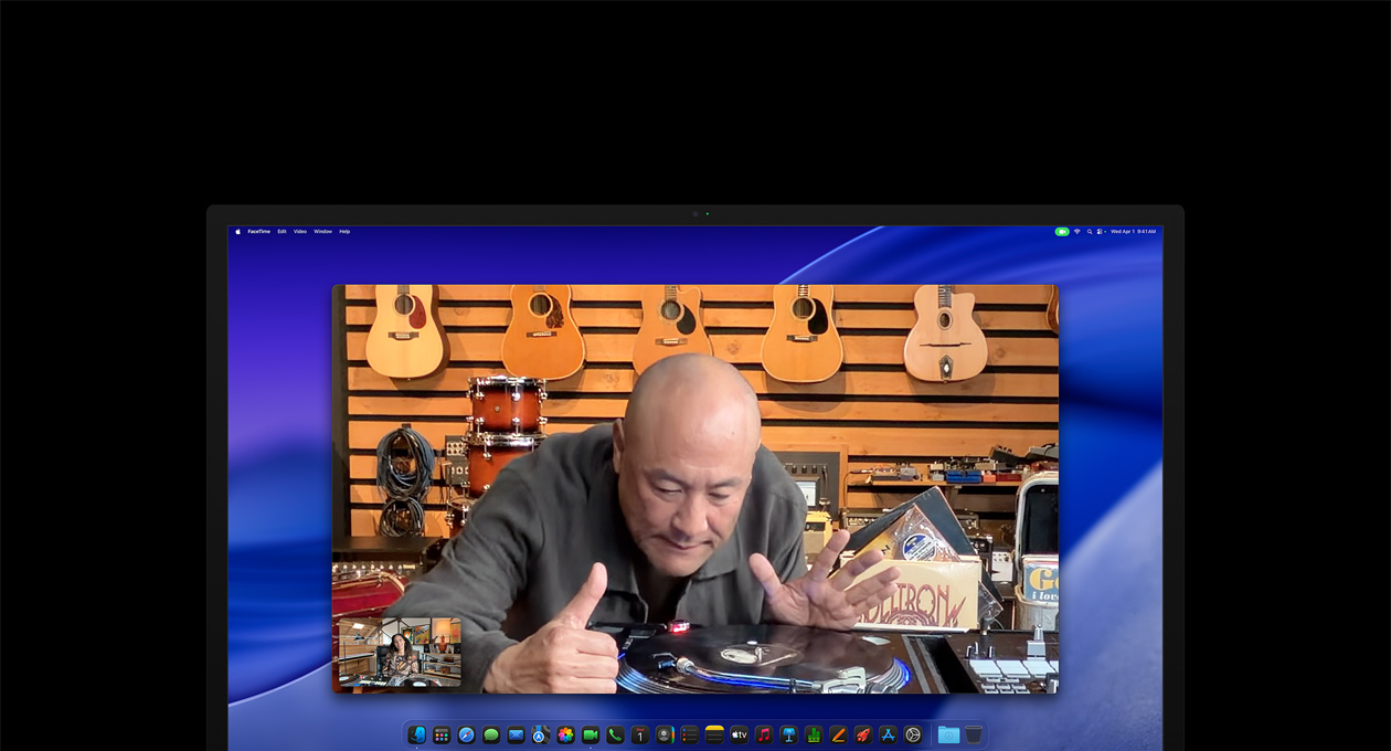 Докато води видеоразговор, човек в музикален магазин разглежда отблизо грамофон, но остава центриран в кадър, благодарение на камерата Center Stage