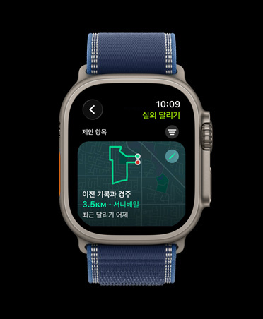 실외 달리기 운동의 특정 경로 기록 경주가 보이는 내추럴 색상 티타늄 케이스의 Apple Watch Ultra 3, 그리고 블루/브라이트 블루 색상 트레일 루프