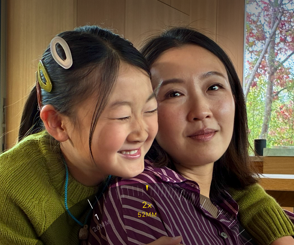 Naudojama „2x Telephoto“ funkcija, priartinamas dviejų apsikabinusių žmonių vaizdas