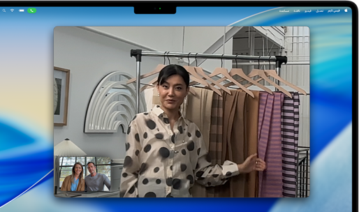 مكالمة فيديو على MacBook Pro تظهر فيها امرأة تعرض أقمشة لشخصين في المكالمة، بينما يحافظ نمط 'في الوسط' على بقائها في وسط الإطار أثناء تحركها