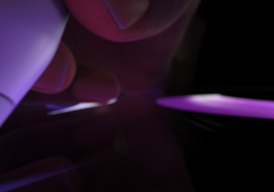 Uživatel drží Apple Pencil Pro úchopem pro psaní. Hrot je přitlačený k displeji a kreslí tlusté tahy jasně zelenou barvou.