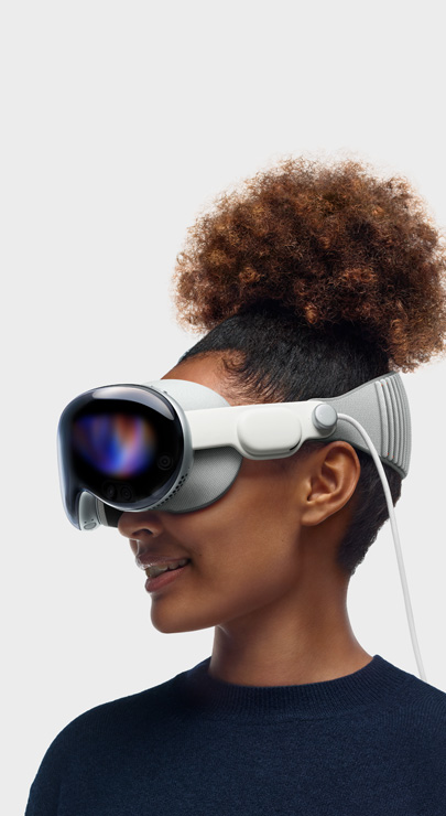 一名員工面帶微笑戴著 Apple Vision Pro 觀看內容