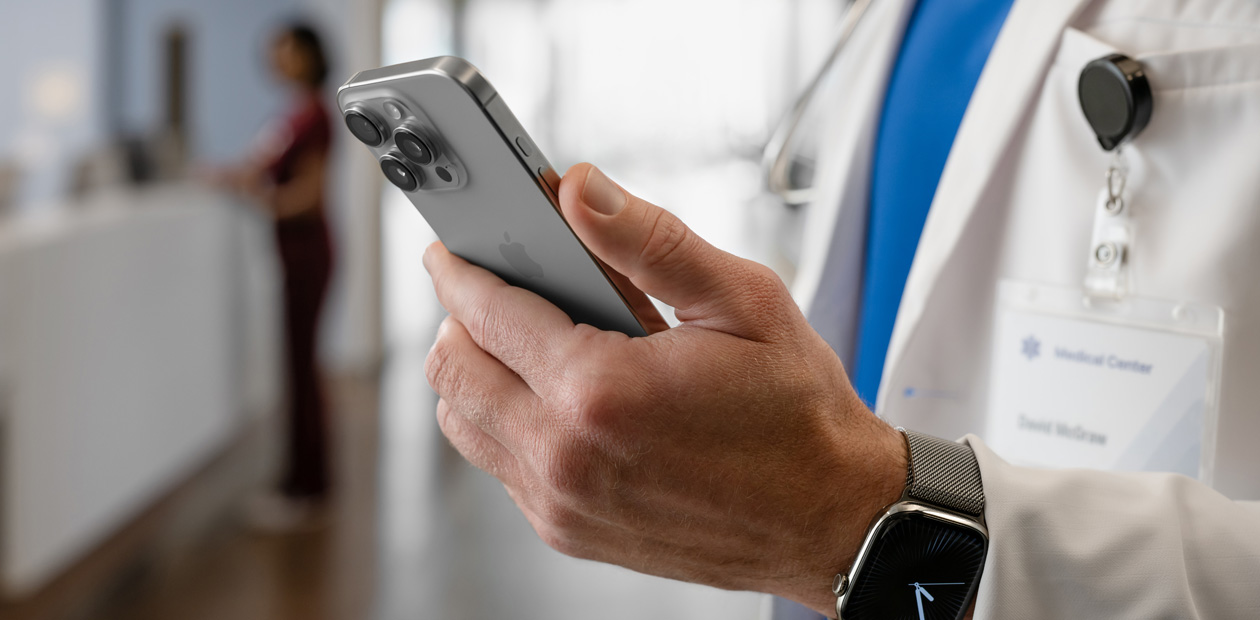 En læge holder en iPhone i hånden.