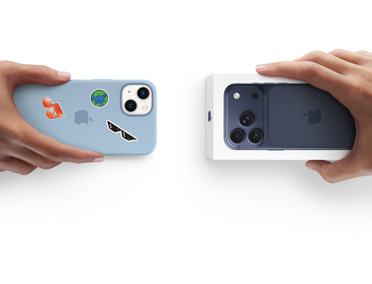 Due mani che si scambiano un iPhone 13 usato con custodia in silicone coperta di adesivi sul retro e un iPhone 17 Pro nuovo ancora nella confezione.